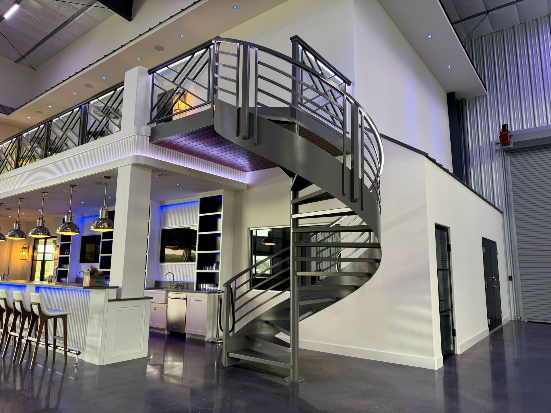 Modern bar and lounge with a spiral staircase and mezzanine seating area