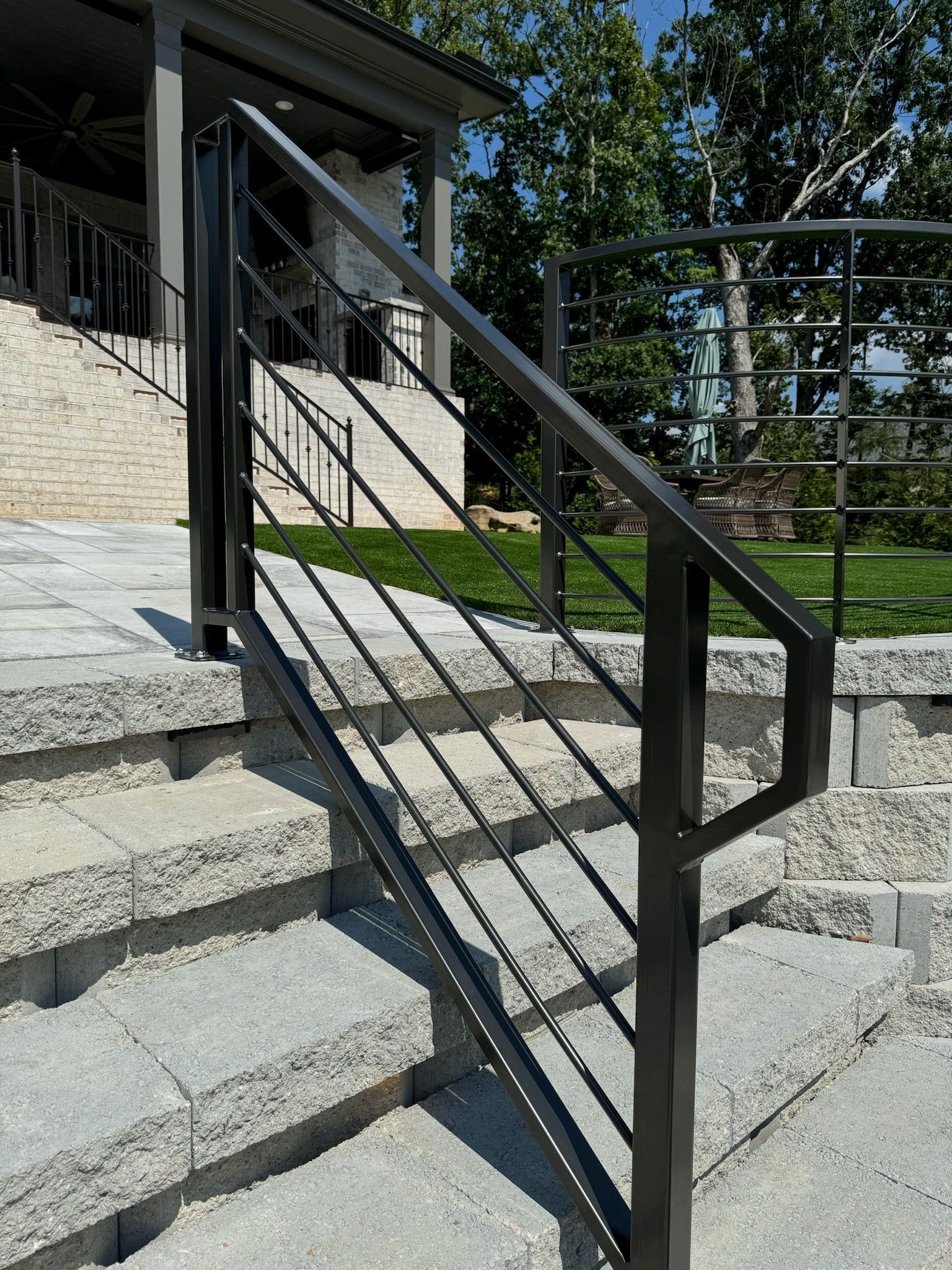 Black metal handrail on concrete steps outside a building