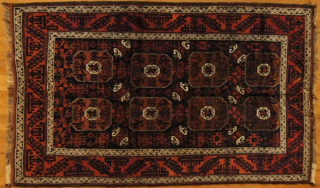Red and black Oriental rug with geometric patterns and a central medallion design.