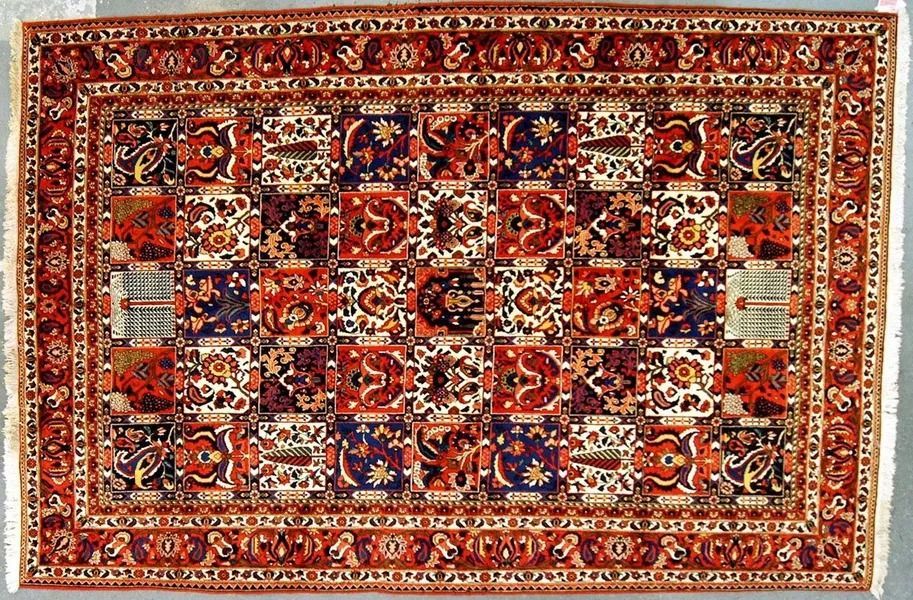Oriental rug with repeating red, blue, and white geometric patterns, fringed edges.