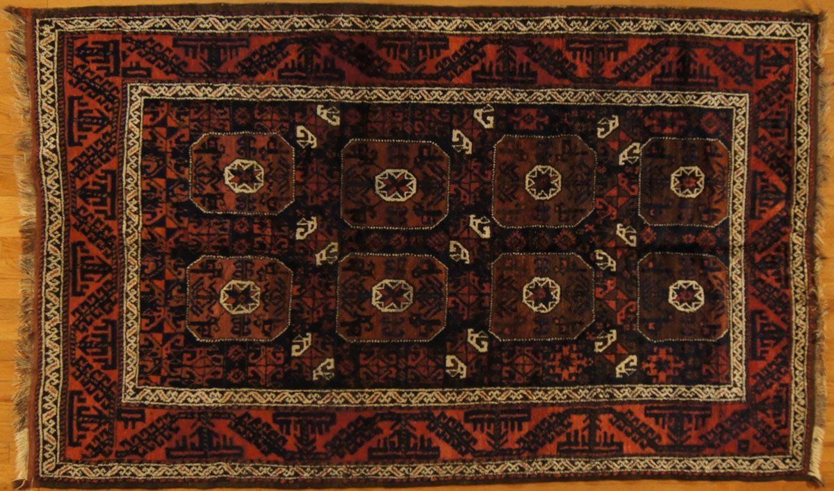 Red and brown oriental rug with repeating octagonal medallion pattern and border.