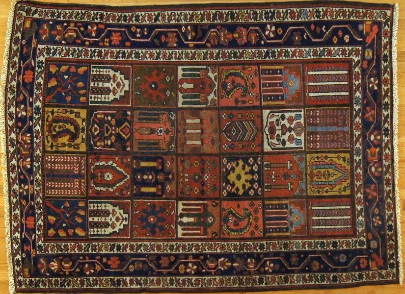 Rug with a dark blue border and a repeating pattern of squares in various colors and designs.