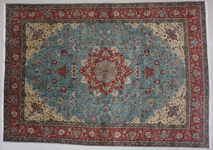 Blue and red ornate oriental rug with floral and geometric patterns.