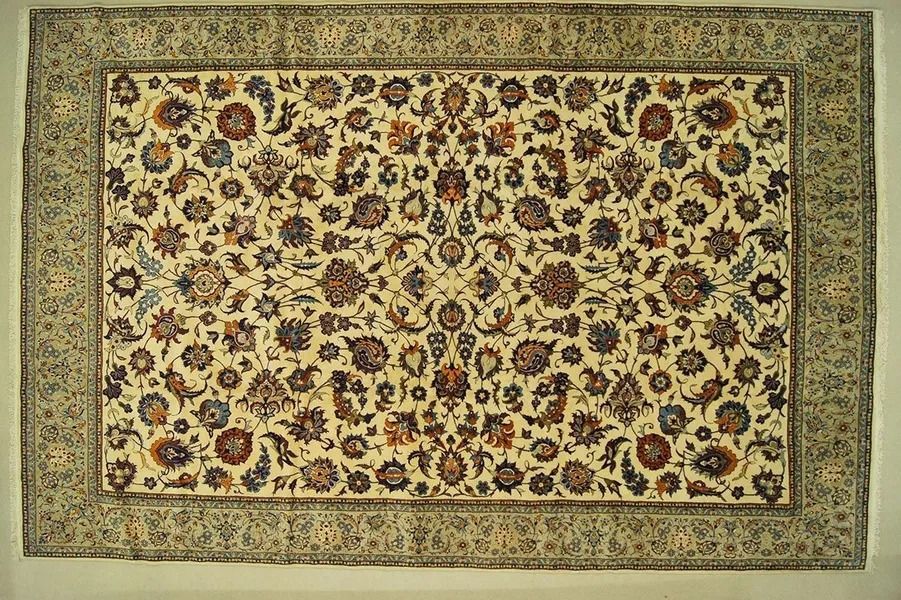 Floral patterned rug with cream background, border and dark blue, brown and rust blooms.