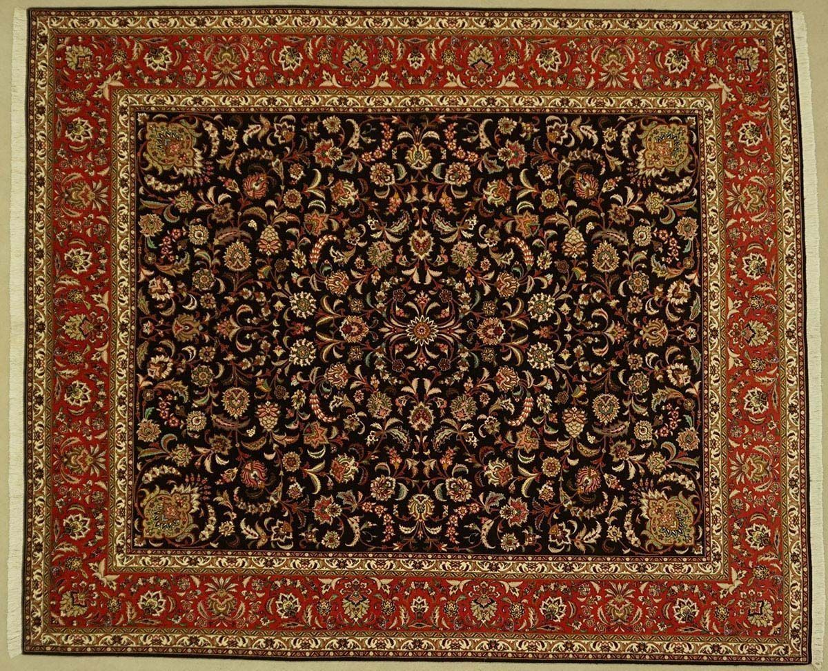 Oriental rug with a dark center and red border, floral pattern.