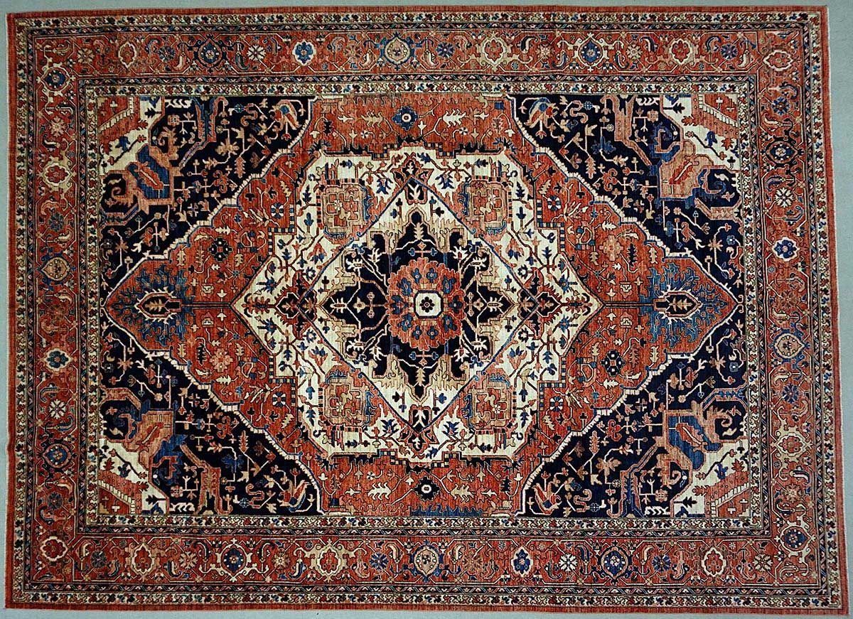 Rectangular rug with a central medallion in cream, navy, and rust colors, surrounded by an intricate floral pattern.