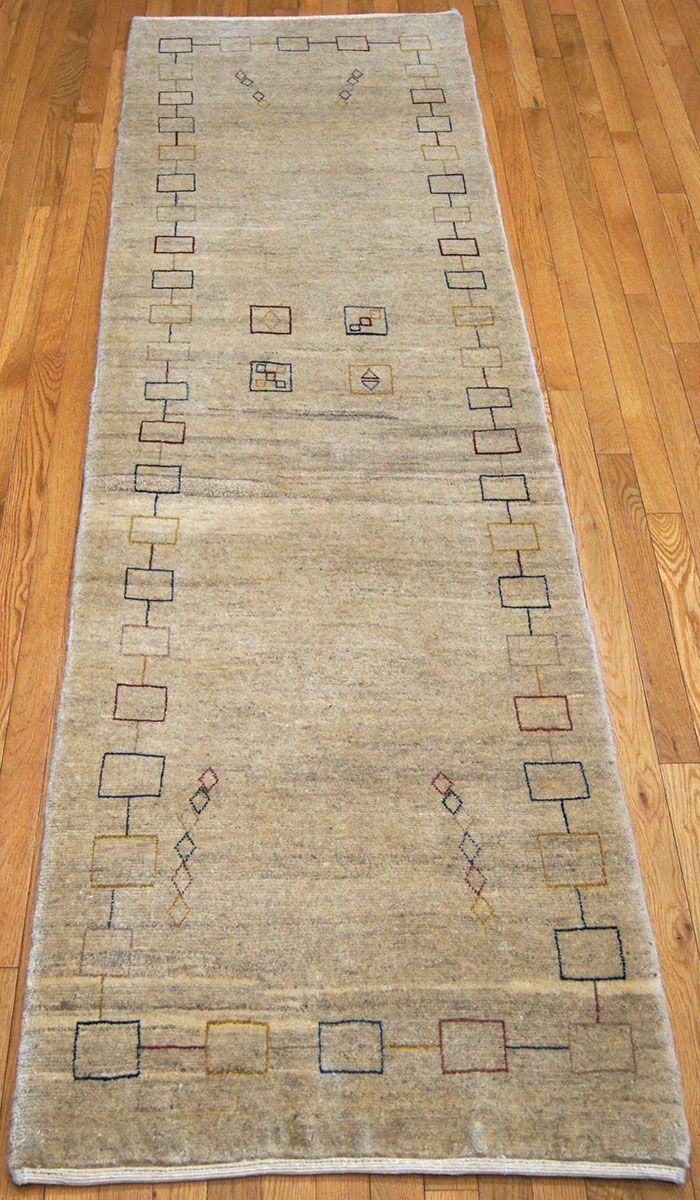 Beige and black rectangular patterned runner rug on wood floor.
