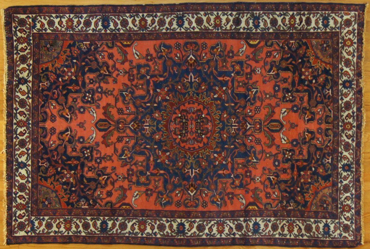 Oriental rug with a red and blue central pattern, bordered by white and brown floral motifs.