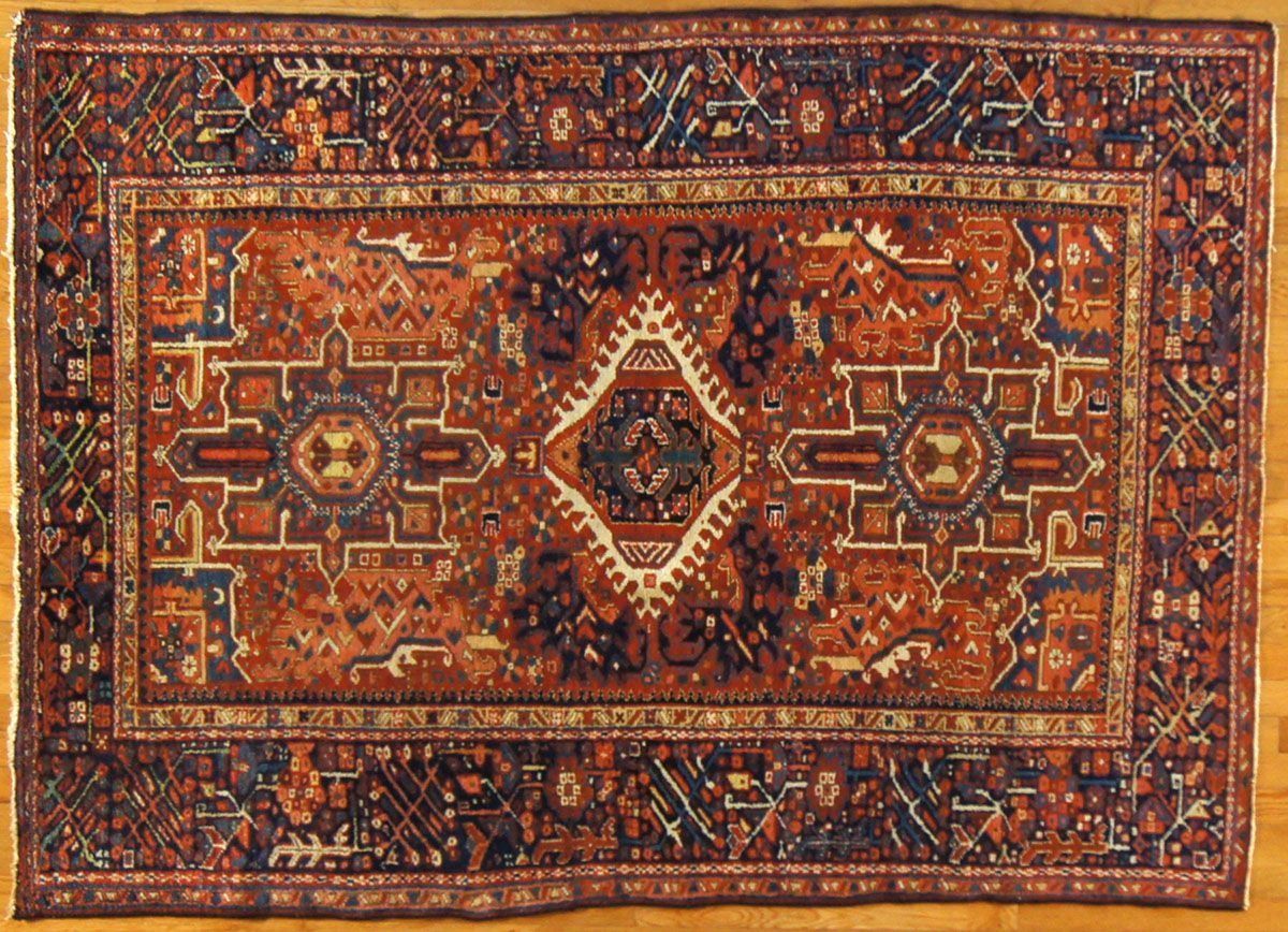 Red and navy rectangular Oriental rug with central medallion and intricate border.