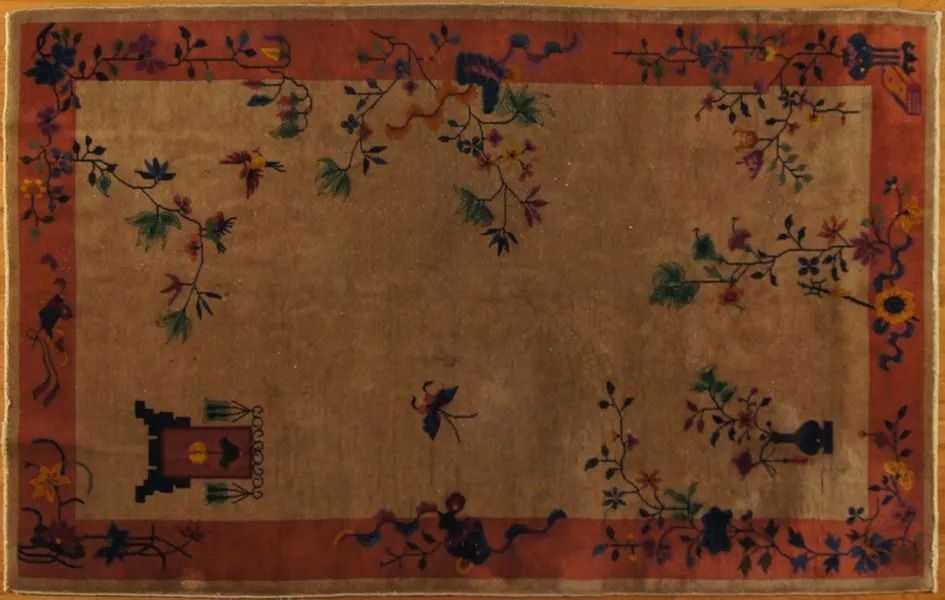 Tan rug with floral and bird designs, bordered in red.