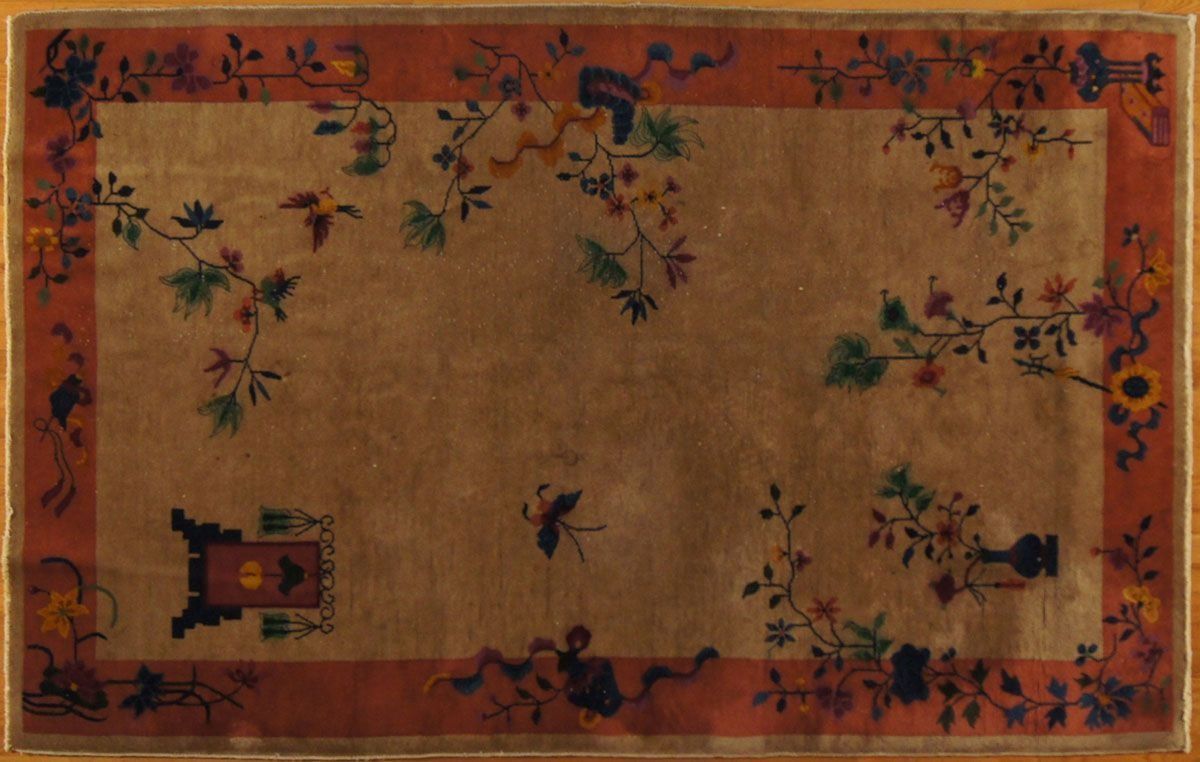 Tan and red Oriental rug with floral and bird motifs.
