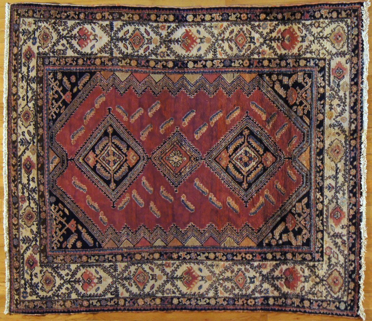 Red and black Oriental rug with repeating geometric border designs.