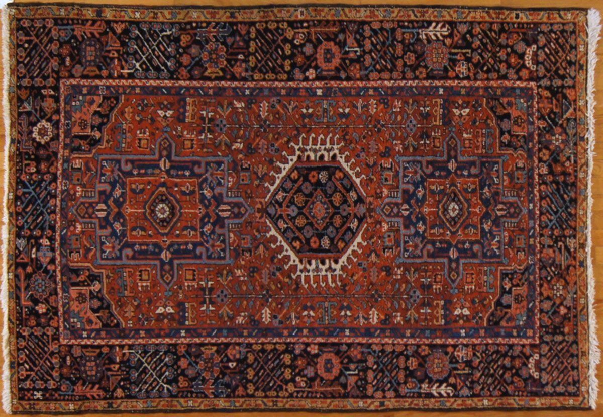 Dark red and navy Persian rug with ornate geometric patterns on a gold surface.