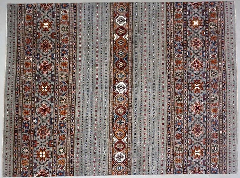 Gray and brown patterned rug with central and side border designs.
