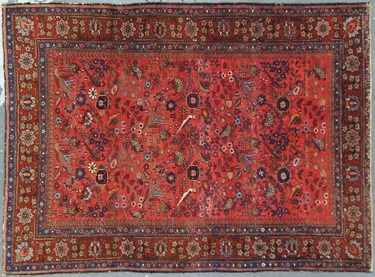 Red and brown Persian rug with floral and bird motifs.