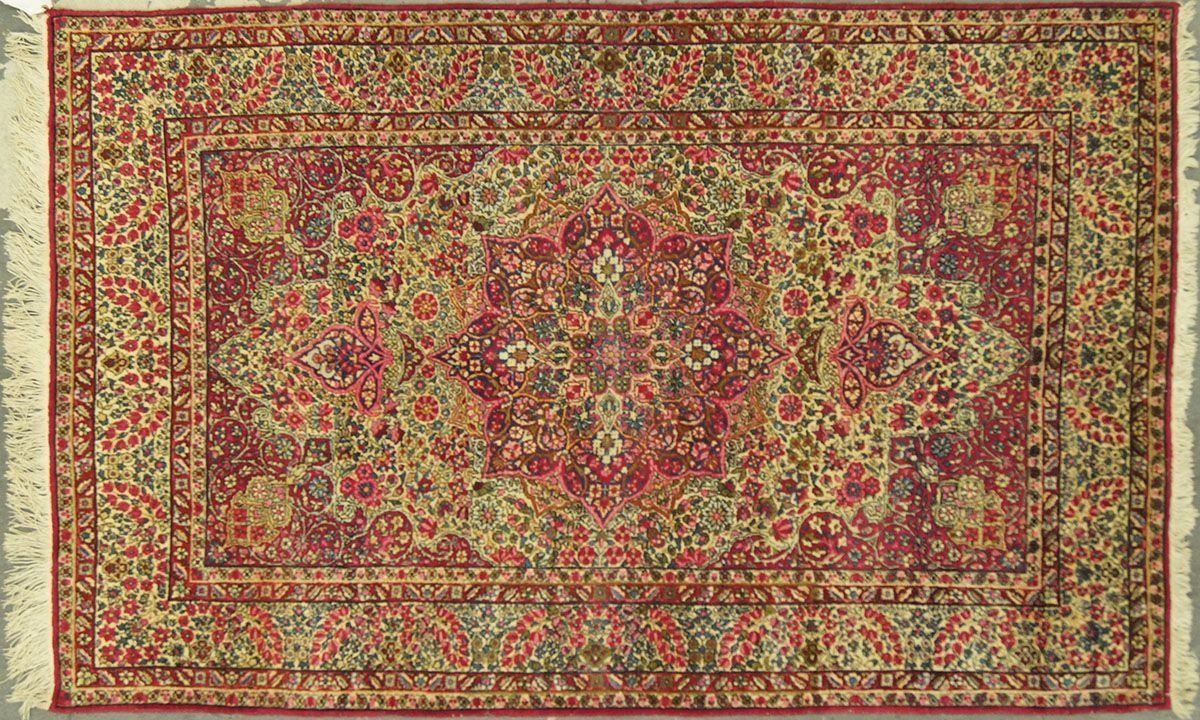 Red and gold rectangular Persian rug with detailed floral patterns.