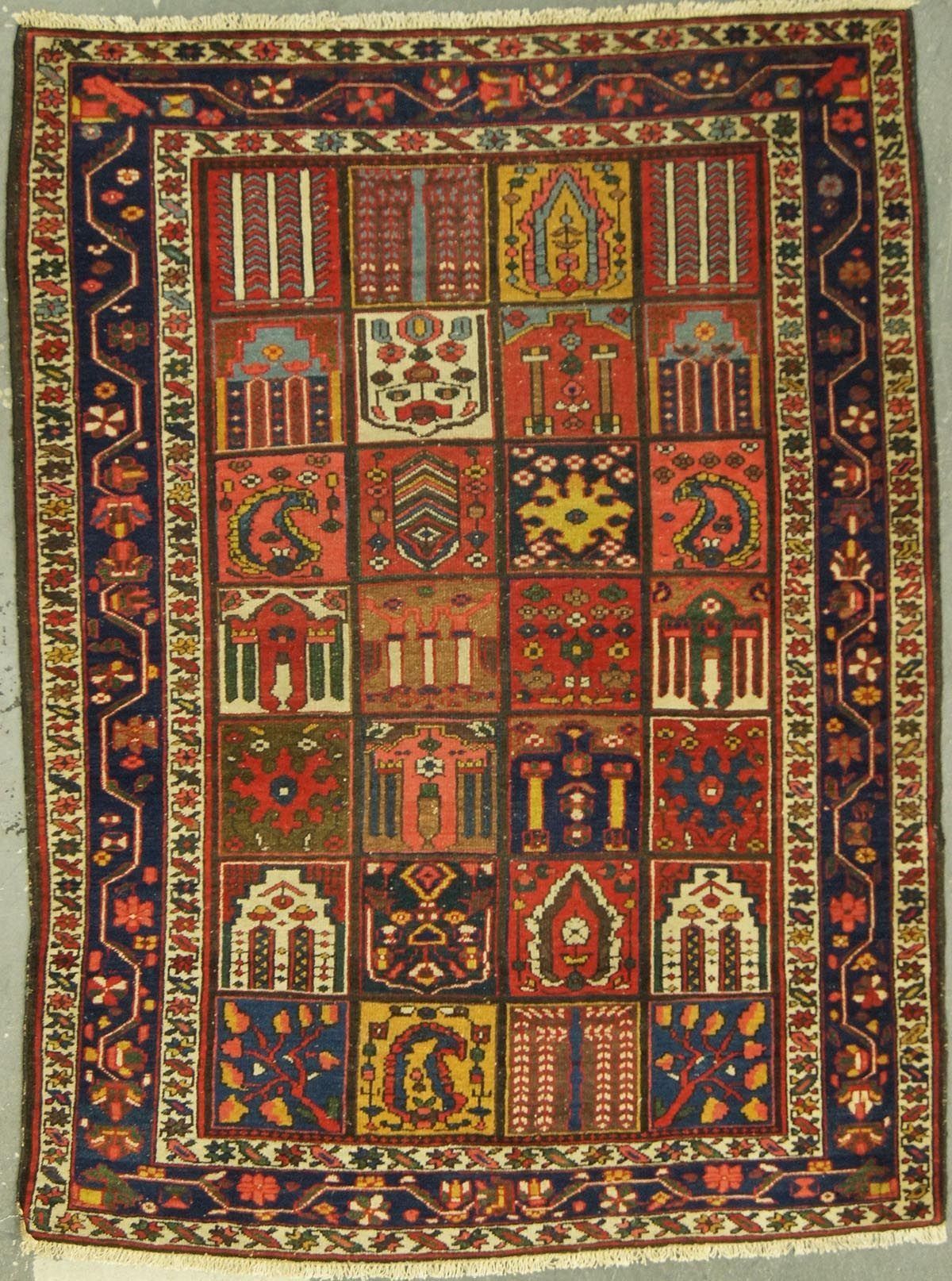 Colorful rectangular rug with a grid of decorative squares, featuring various geometric and floral patterns.