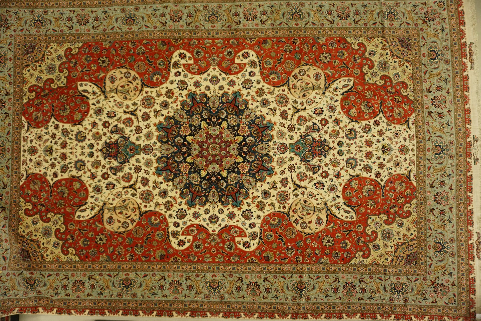 Oriental rug, cream and red with floral and geometric patterns.