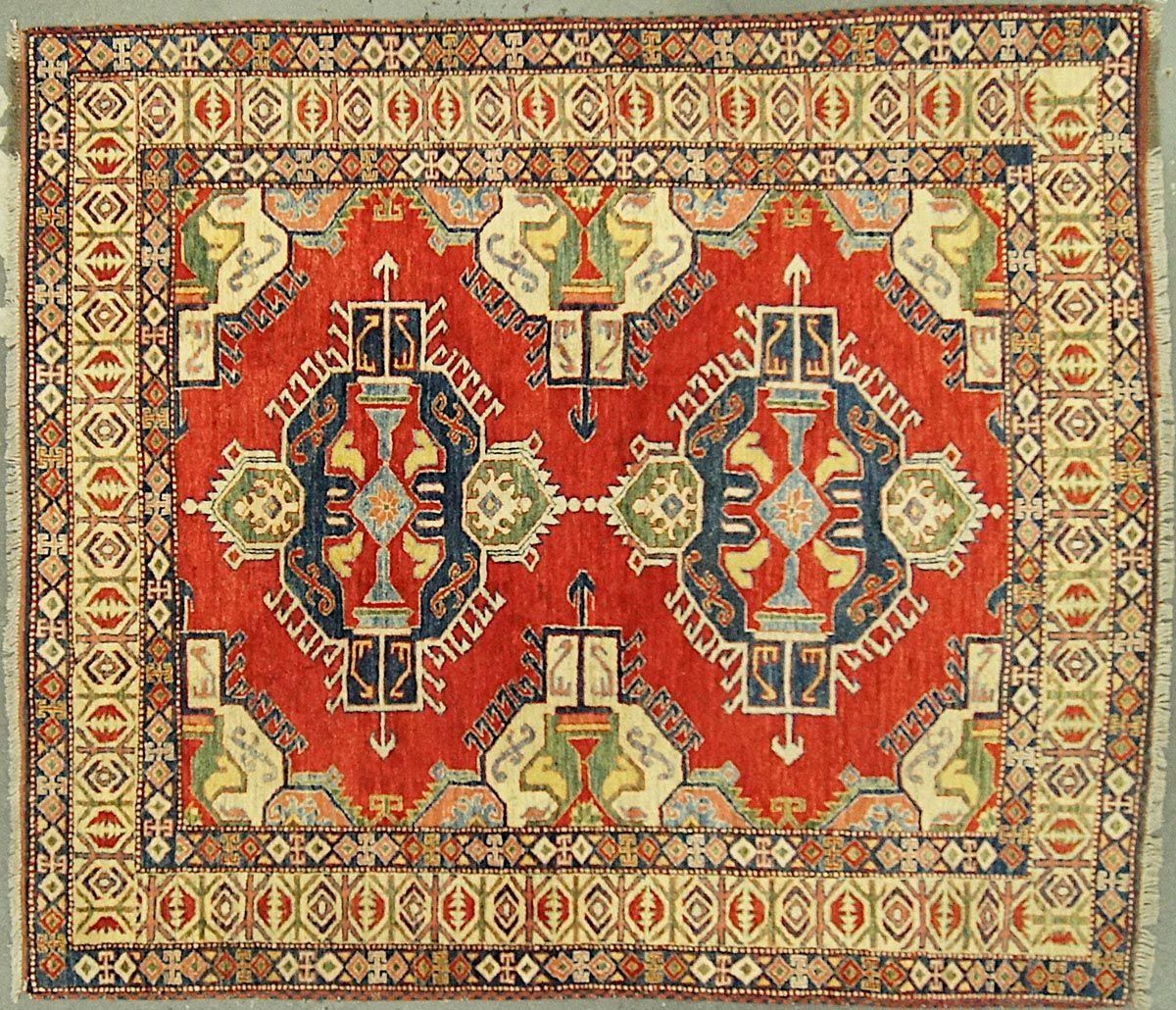 Red and beige oriental rug with intricate geometric patterns and a detailed border.