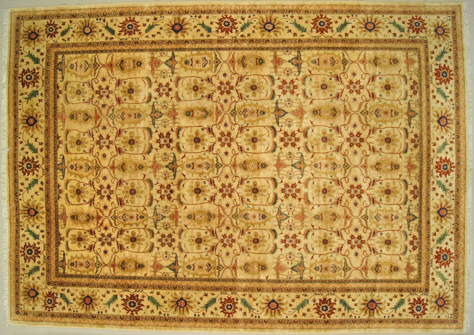 Tan and red patterned rectangular rug with a floral border.