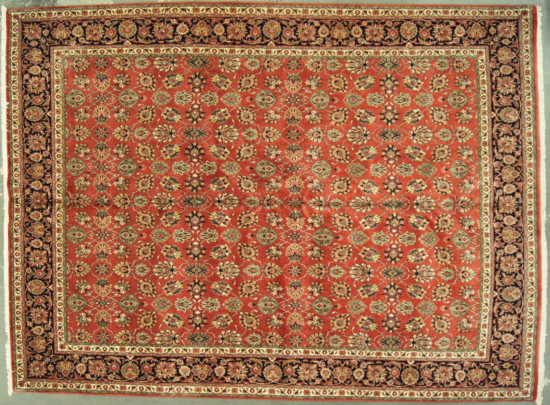 Red and beige patterned oriental rug with a dark border.