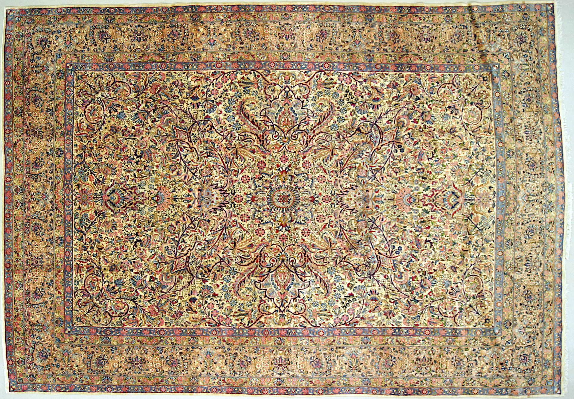 Beige and brown patterned rug with a detailed floral design and border.