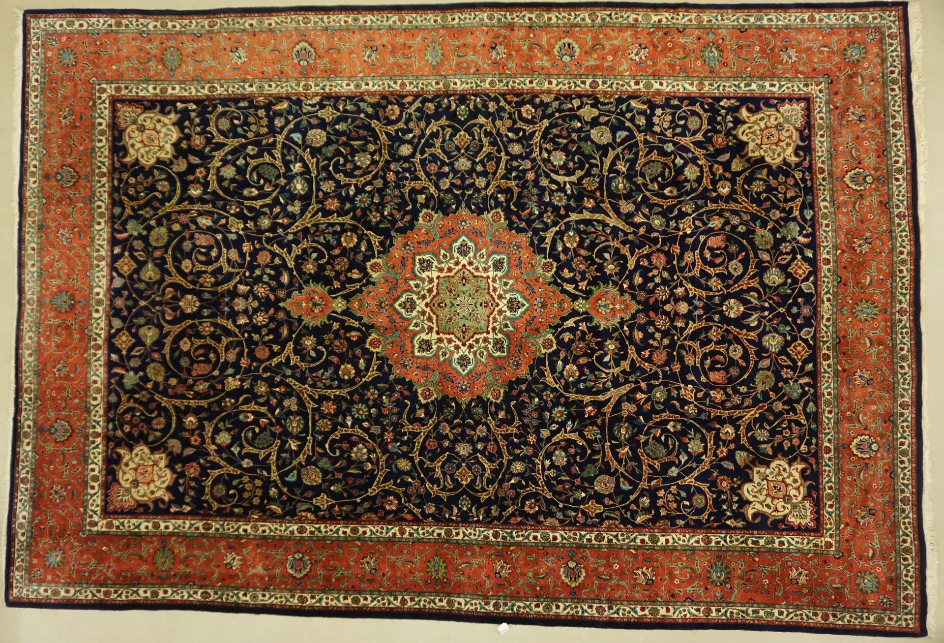 Navy blue rug with rust-colored border and intricate floral patterns.