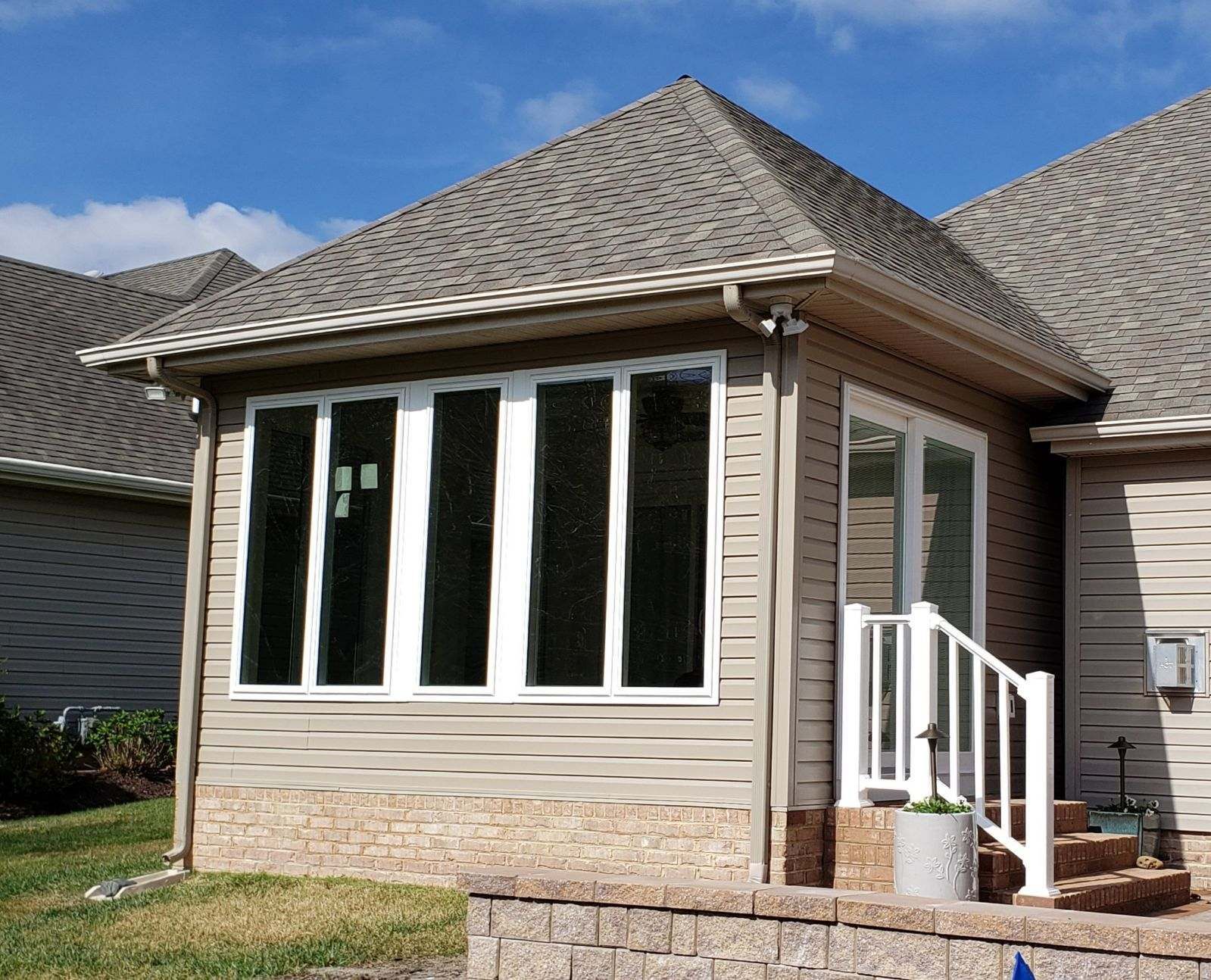 A house with a screened in porch and stairs.