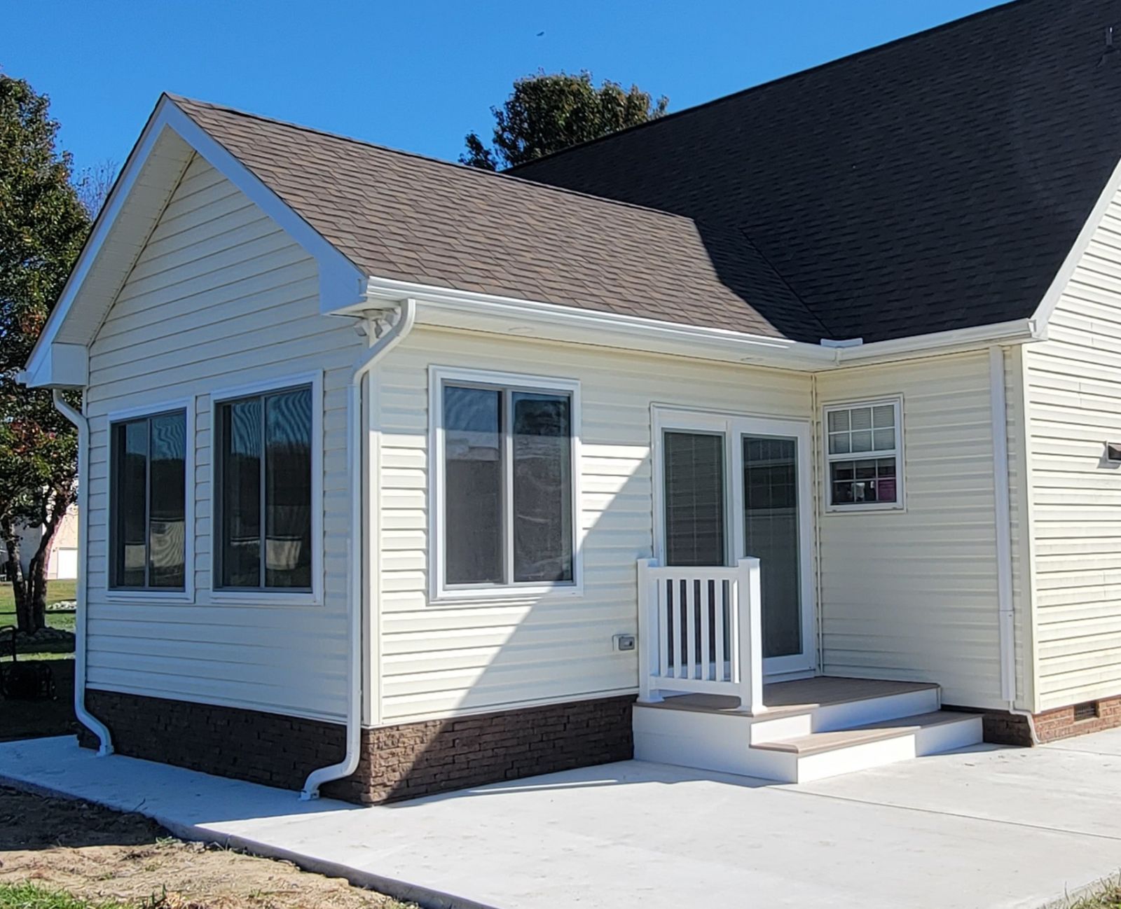 A small white house with a brown roof