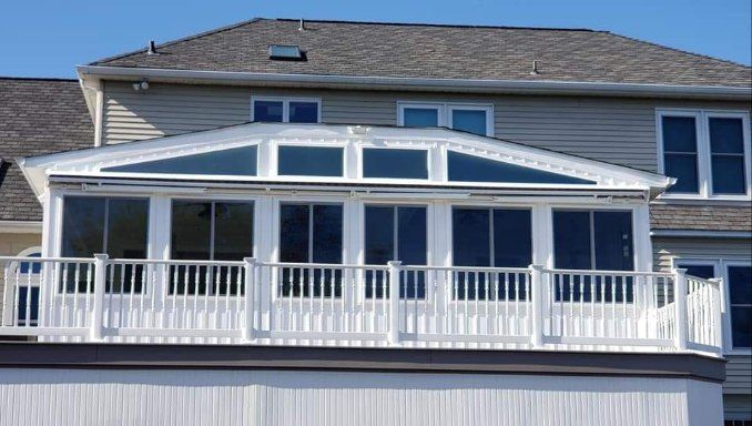 A house with a screened in porch and a balcony
