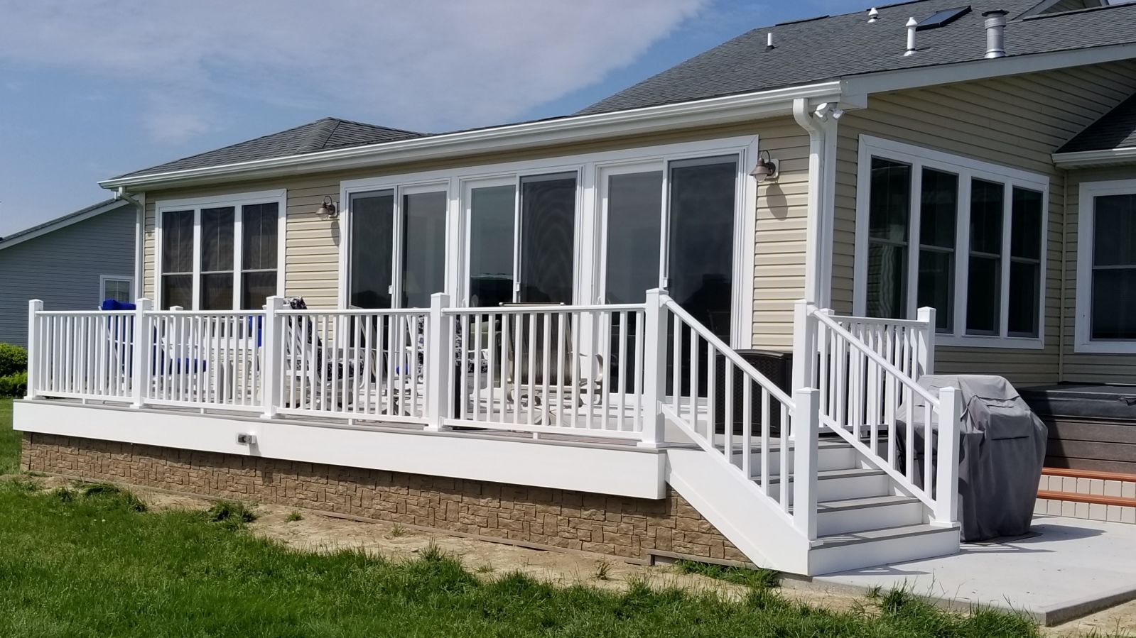 A house with a large deck and stairs in front of it.
