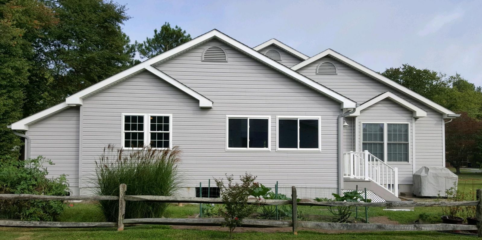 A white house with a wooden fence in front of it