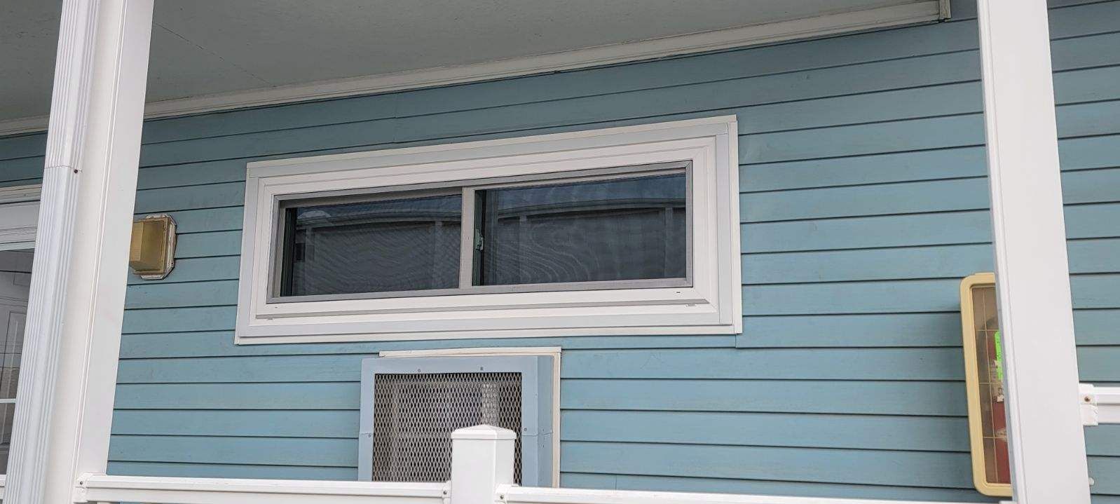 A blue house with a white porch and a window