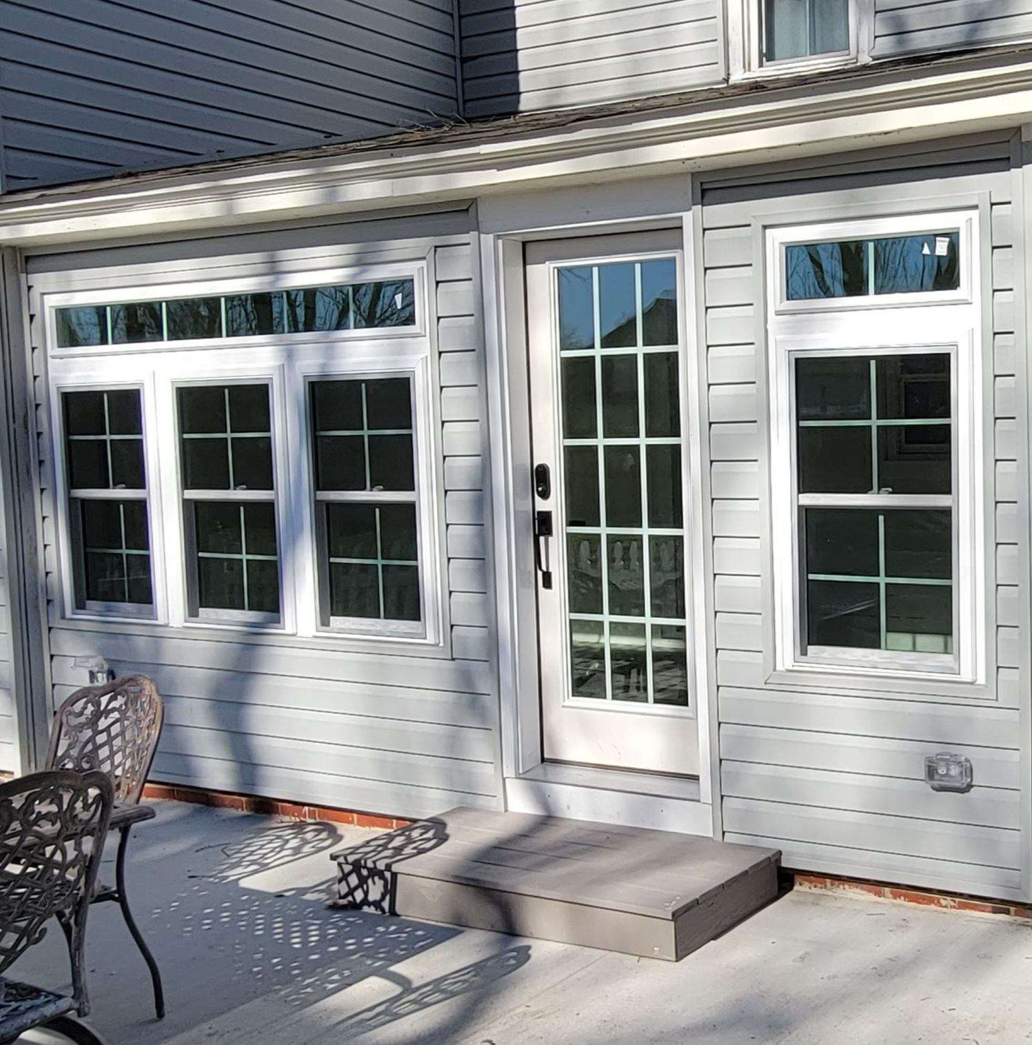 A patio with a table and chairs in front of a house