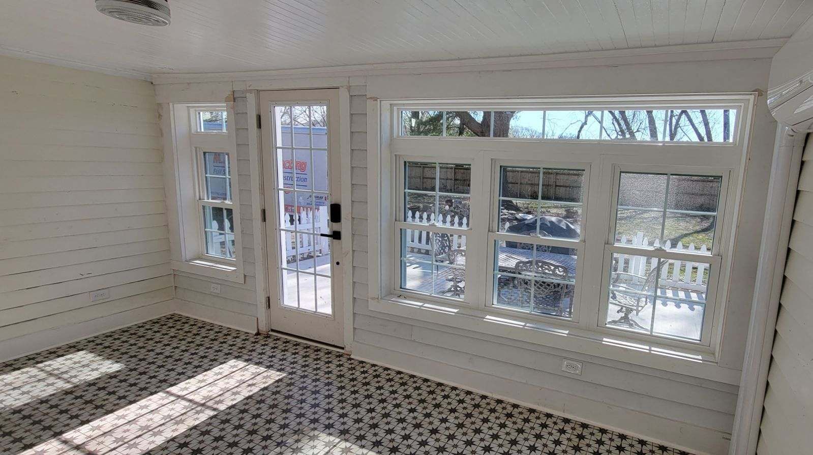 A room with a lot of windows and a door.