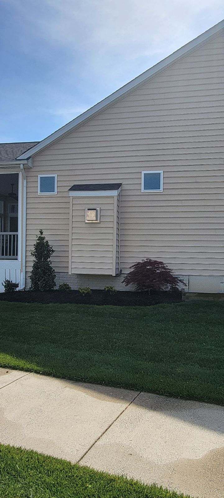 A house with a mailbox on the side of it next to a sidewalk.