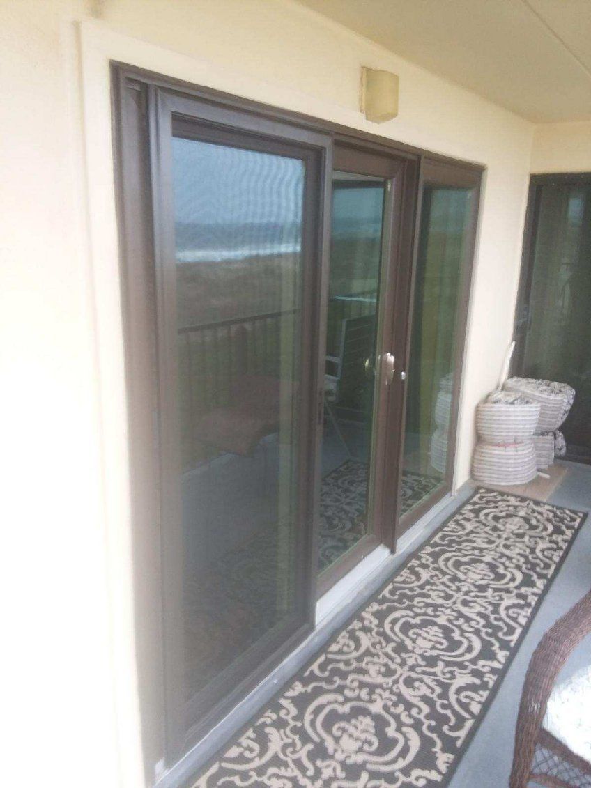A balcony with sliding glass doors and a rug.