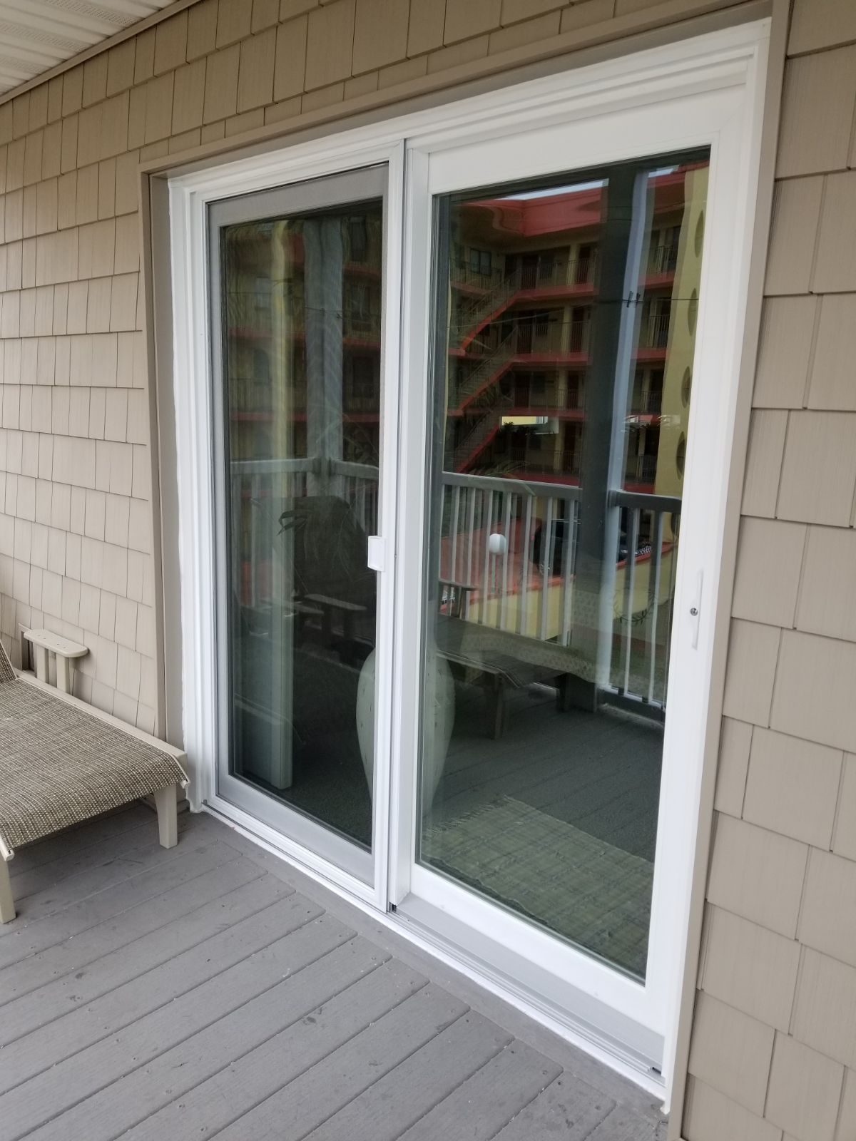 A white sliding glass door is open to a balcony.