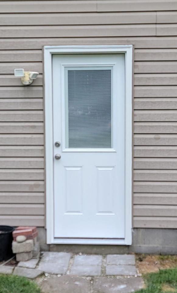 A white door with a window on the side of a house.