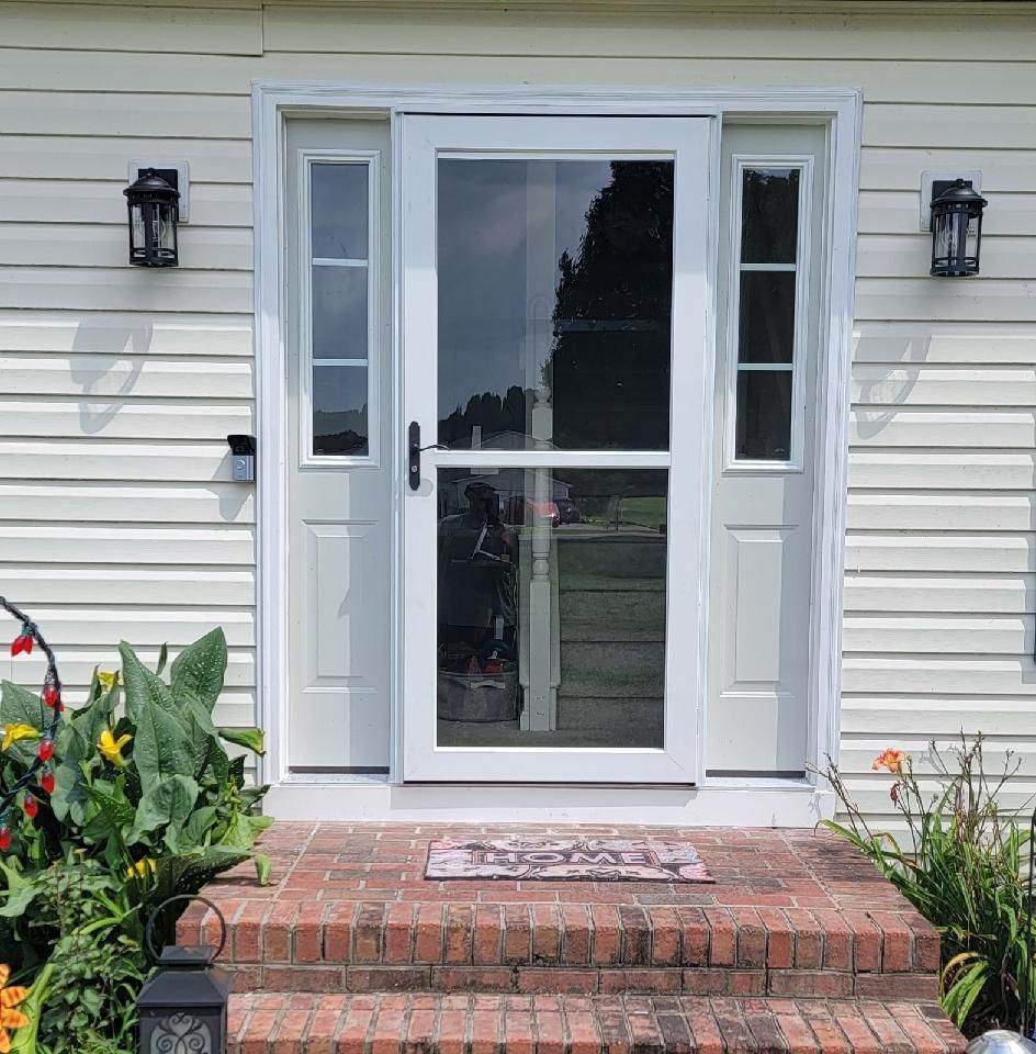 A white house with a sliding glass door and brick steps