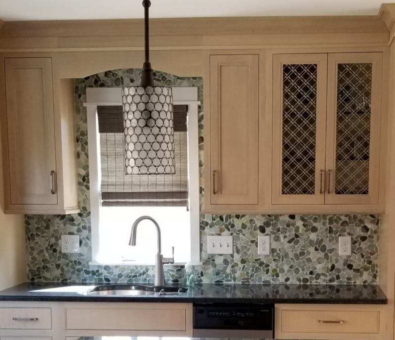 A kitchen with a sink, a window and a pendant light