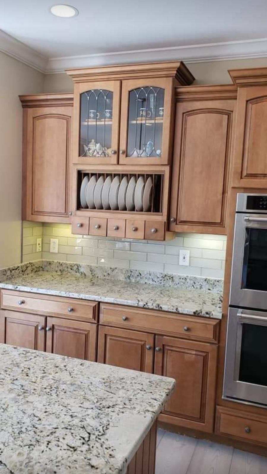 A kitchen with wooden cabinets, granite counter tops, and stainless steel appliances.