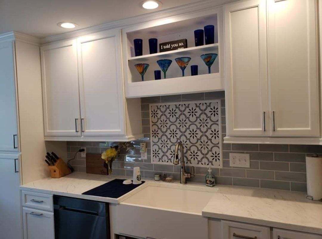A kitchen with white cabinets, a sink, and a dishwasher.