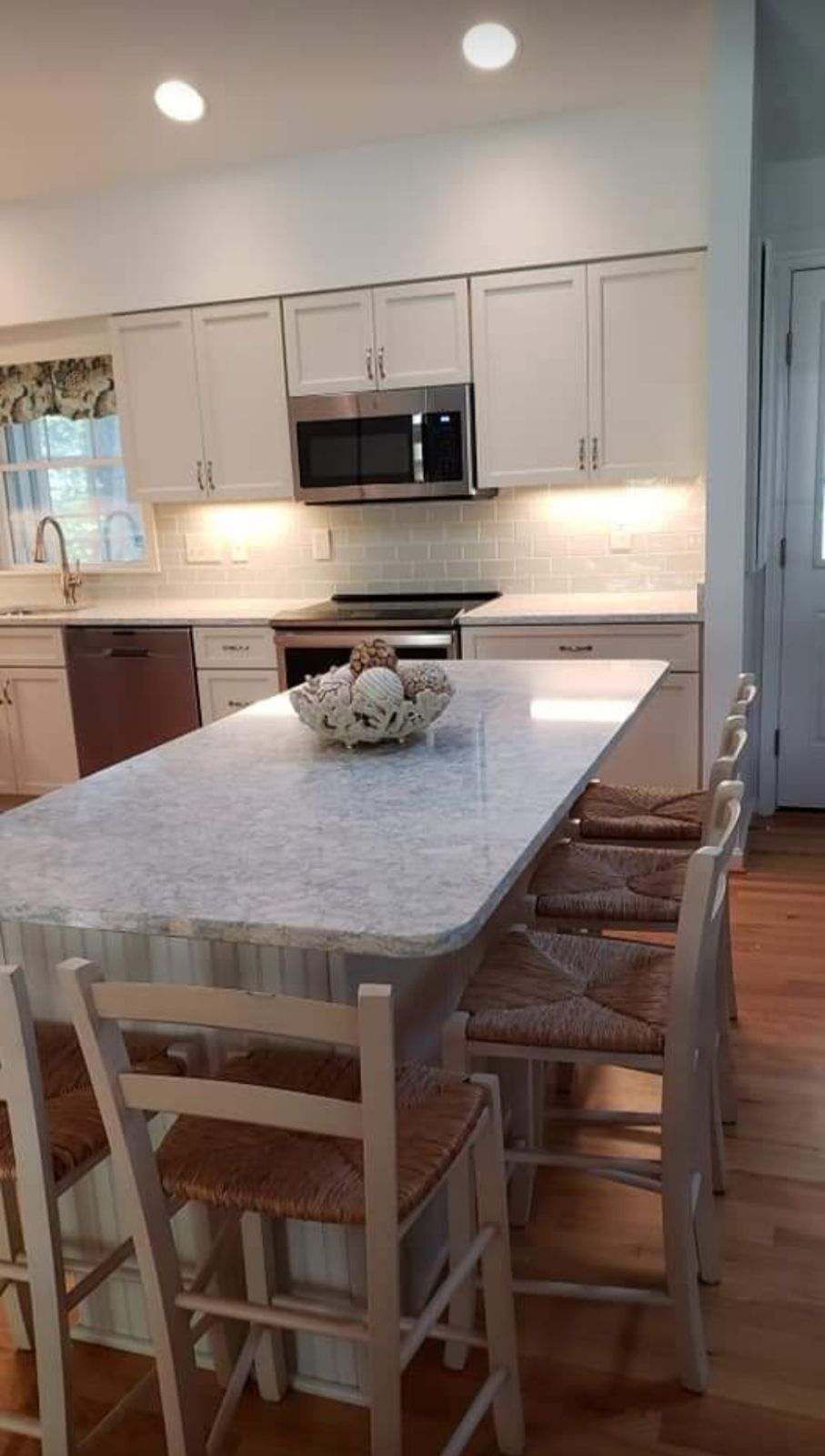 A kitchen with a table and chairs and a microwave.