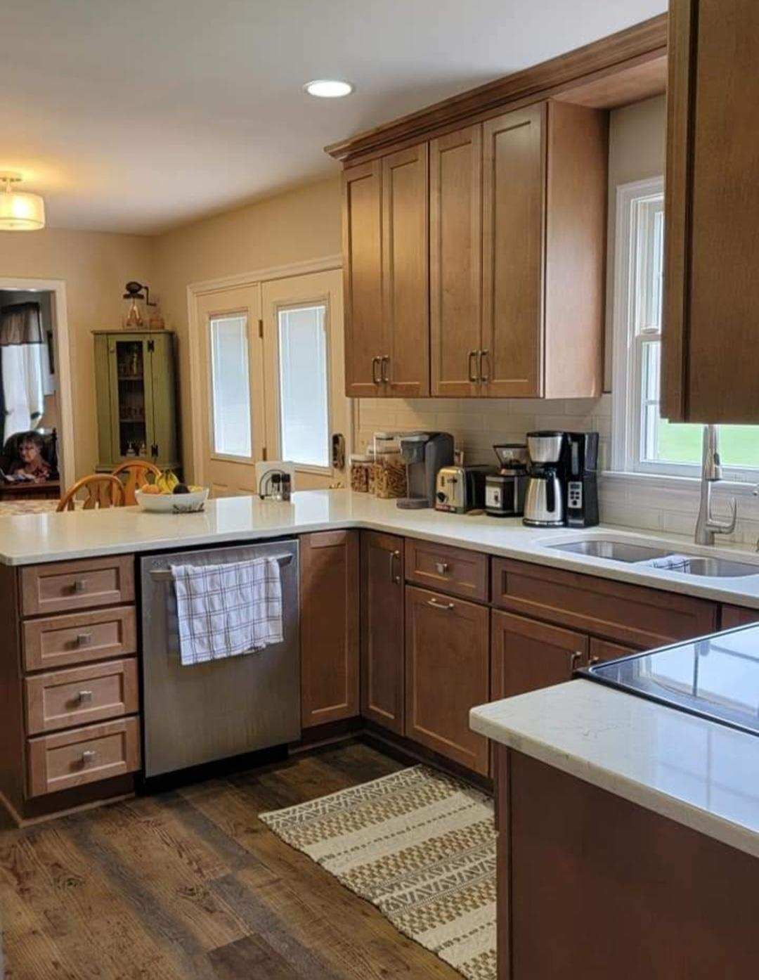 A kitchen with wooden cabinets, stainless steel appliances, a sink, and a window.