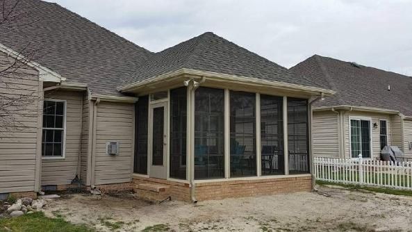 A screened in porch is being built on the side of a house.