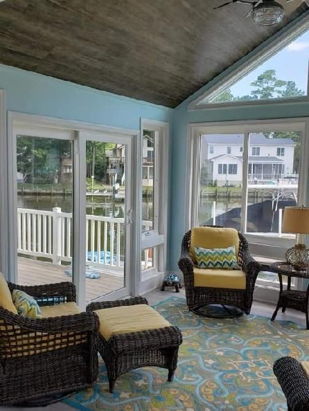 A living room with wicker furniture and a ceiling fan