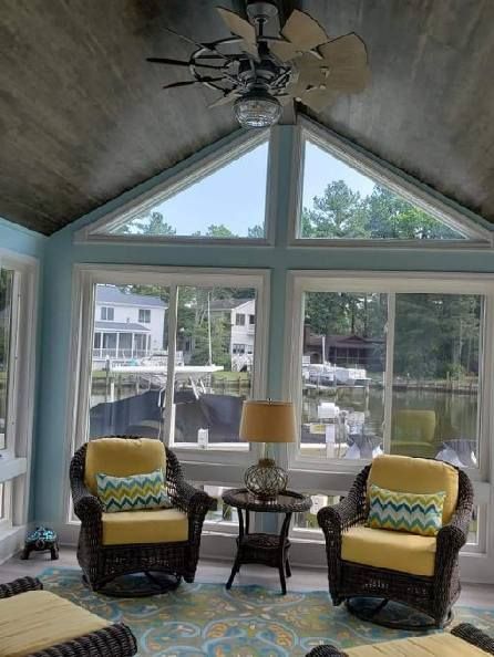A living room with a lot of windows and a ceiling fan