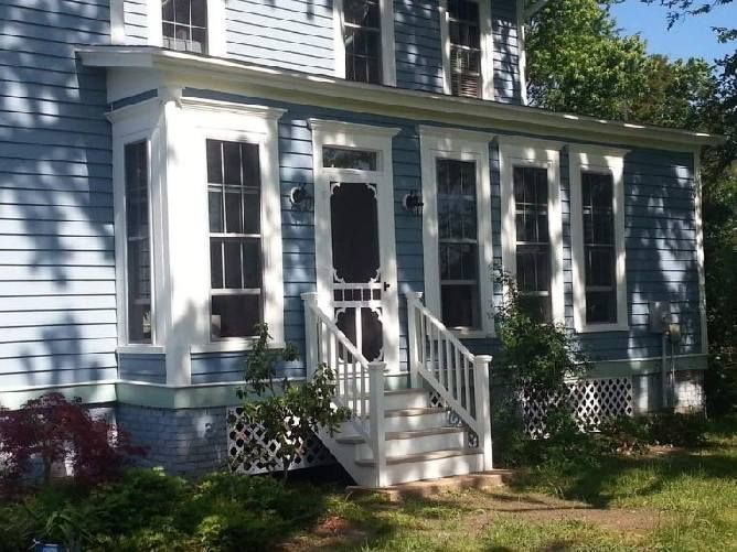A blue house with a white porch and stairs
