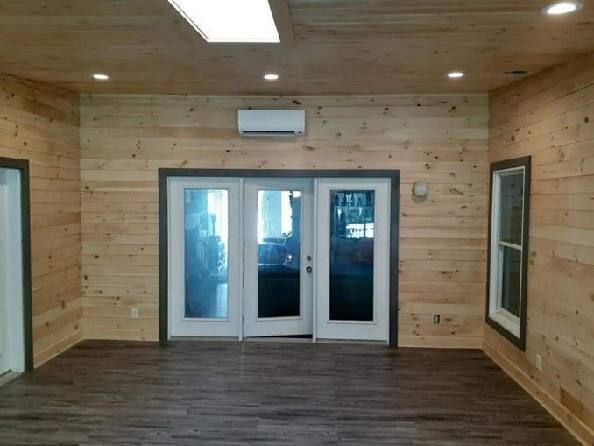 A room with wood paneling and sliding glass doors.